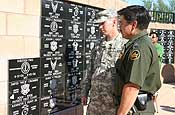 A U.S. Army 2nd Lt., left, of the Arizona National Guard and the assistant chief patrol agent at the Yuma Sector of the U.S. Border Patrol, look at a memorial plaque added to the Veterans Memorial in Armed Forces Park, Yuma, Ariz., Sept. 7, 2006. The plaque honors Pennsylvania National Guardsman Spc. Kirsten Fike who died while on duty along the U.S./Mexico border in southern Arizona. National Guard Soldiers and Airmen are working with the U.S. Border Patrol as part of Operation Jump Start, a mission ordered by President Bush to tighten security along the nation's southern border. (U.S. Army photo by Pfc. Monette Wesolek)