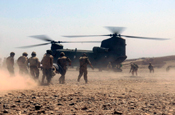 Members of the Oregon Army National Guard, along with members of the Afghan National Army, help carry wounded personnel to a CH-47 Chinook helicopter near the Helmand Province in Afghanistan in Aug. 2008. (Photo by Charles Eckert)