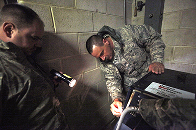 Staff Sgt. Robert Jentsch, left, shines a flashlight onto the control panel of a generator for Staff Sgt. Carl Hilpl as Hilpl prepares to start the system so the shelter at Veterans Memorial Middle School in Brick, N.J., will have power Nov. 7, 2012.