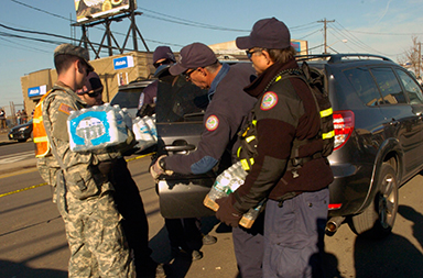 New York Army National Guard members distribute supplies to residents after Hurricane Sandy devastated the area.