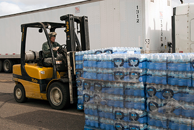 A Connecticut Army National Guard soldier moves pallets of water into position for loading and delivery near Rentschler Field, East Hartford, Conn., Oct. 30, 2012. The National Guard set up a commodity distribution point at the site in order to facilitate delivery of Federal Emergency Management Administration-supplied food and water to Connecticut towns hit hard by Sandy.