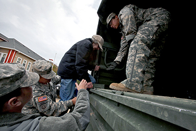 Soldiers assigned to Task Force South, New Jersey National Guard, assist a Long Beach Islander onto a M939 5-ton 6x6 truck during relief operations Oct. 31, 2012. The New Jersey National Guard is working with Long Beach Island civilian authorities in the aftermath of Hurricane Sandy.