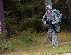 Spc. Ryan Montgomery, an infantryman with the Arkansas National Guard’s 39th Infantry Brigade Combat Team, emerges from the tree line towards a warrior task and battle drill lane at the 2014 Department of the Army Best Warrior Competition at Fort Lee, Va., Oct. 7, 2014. Montgomery represented the Army National Guard as its top enlisted Soldier of the year. (Army National Guard photo by Staff Sgt. Darron Salzer, National Guard Bureau)(Released)