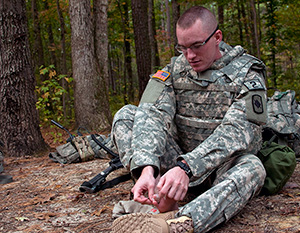Spc. Ryan Montgomery, an infantryman with the Arkansas National Guard’s 39th Infantry Brigade Combat Team, checks his feet for injuries while waiting for the next event of the 2014 Department of the Army Best Warrior Competition, Oct. 7, 2014 at Fort Lee, Va. Montgomery represented the Army National Guard as its top enlisted Soldier of the year. (Army National Guard photo by Staff Sgt. Darron Salzer, National Guard Bureau)(Released)