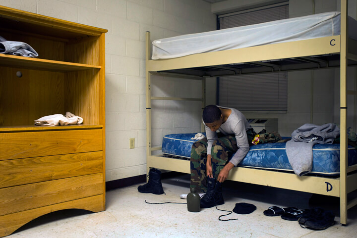 Raymond Colbert laces up his boots as he prepares for the day.