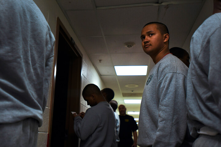 Ronny Colindras keeps an eye on his squad members during evening roll call in the academy's barracks.