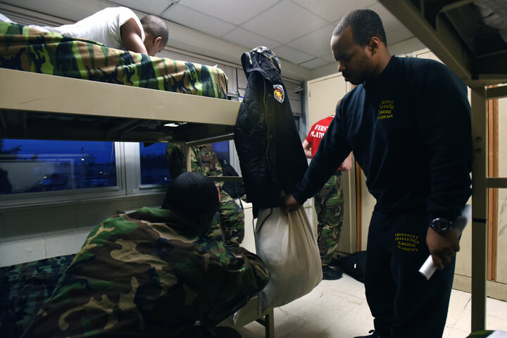 Cpl. Ronald Williams checks the placement of a cadet's laundry bag
