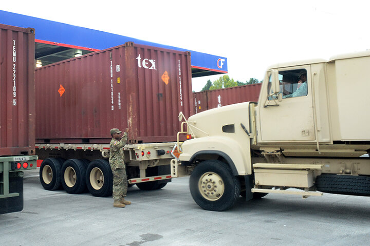 Army Sgt. Charles Wallace directs the driver of a another truck as he pulls into a fuel point.