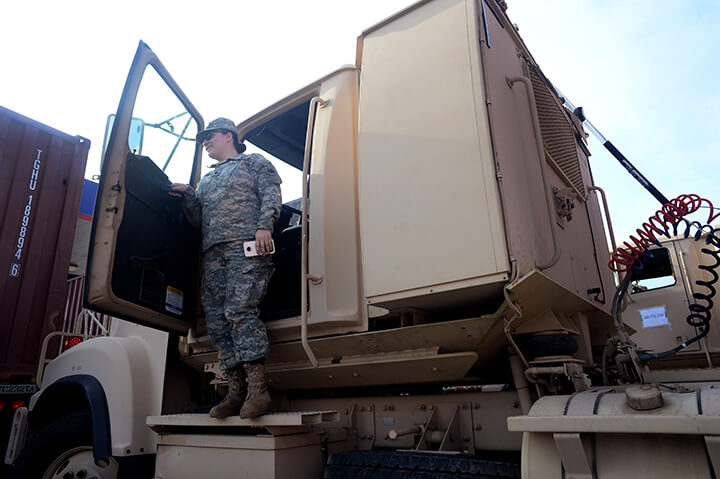 Spc. Michaela Schiesser steps out from the cab of her truck after pulling into a fuel stop.