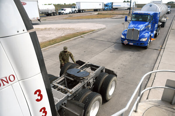 Tires can serve as hiding spot for illegal drugs and other items. To ensure nothing is hidden inside, Spc. Afeez Amusan, a truck driver with Co. A, 536th BSB, taps the tires of a semi-truck at the Pharr port of entry checking for anything out of the ordinary.