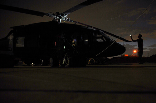 With last light of day filtering through the sky, aircrew members conduct a post-flight inspection on the Black Hawk. Because of the high operational tempo, one of the biggest challenges is ensuring the aircraft is mission ready at all times, said Escobedo. In addition to the OGS missions, the aircraft are also used for a variety of other missions and training requirements.