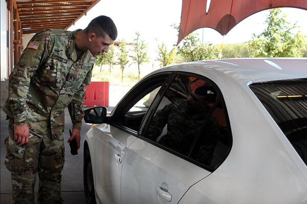 Spc. Nathaniel Snyder, a horizontal construction engineer with the 229th Eng. Co., talks with a driver in the secondary screening lanes at the Nogales port of entry. For many from Snyder's unit, growing their Spanish language skills has been one of their biggest challenges working along the border.