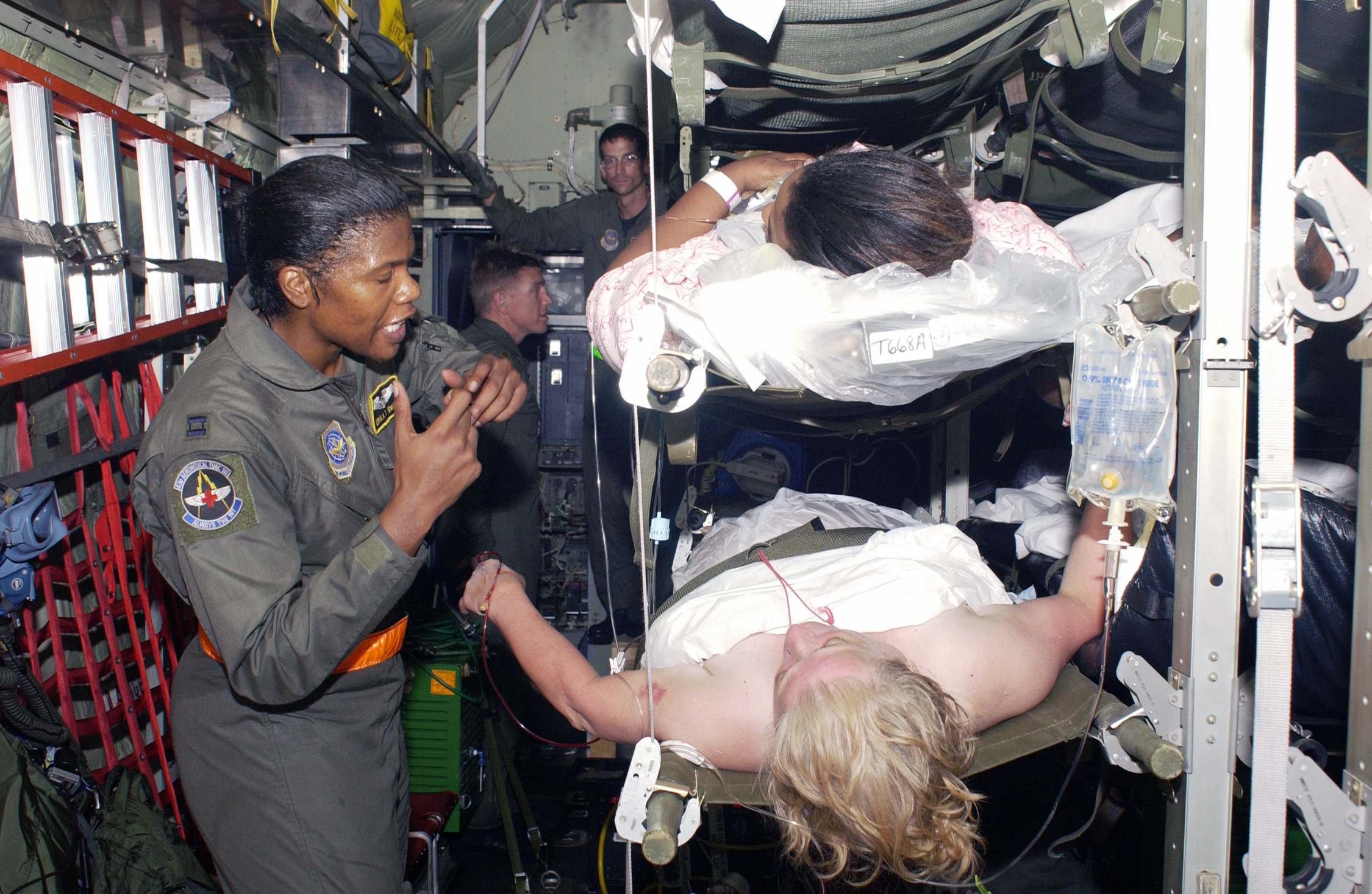 Capt. Erika Smith talks to a patient that is being transported from an airport in New Orleans, La., on Sept. 1, 2005, in the wake of Hurricane Katrina. Patients were taken to awaiting medical personnel in Texas aboard a West Virginia Air National Guard C-130H from the 130th Airlift Wing based in Charleston.