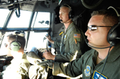 Tech. Sgt. Michael Nix (left) and Lt. Col. Bob Kotula, assigned to the 145th Airlift Wing of the North Carolina Air National Guard, watch for air traffic through smoke and haze as they make their way to the fires in the Lake Shasta area on a firefighting mission July 4.