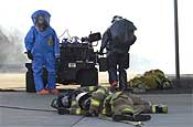 102nd CST Survey Team members, Sgt. Richard Hosmer (left), and Sgt. Paul Edgerly (right), prepare to enter a structure in order to check for Sarin gas contamination. Play actors from Clackamas County Fire lay in the foreground. Hosmer and Edgerly were part of a 102 CST demonstration event at the Marion County Regional Fire Training Facility in Brooks, Ore., on Oct. 27, 2006.