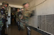 Specialist Andrea Sheehan, of the National Guard Reaction Force rushes out with the rest of her unit to disperse rioting demonstrators during the Vital Guardian Exercise at the District of Columbia National Guard Armory on April 4.