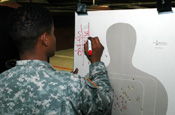 A California National Guard Soldier serving as a range safety officer for the U.S. Border Patrol at the San Diego Sector Small Firearms Range calculates a Border Patrol agent's score during weapons qualification in July. The Citizen-Soldier, participating in Operation Jump Start, is not identified because of security reasons. (Photo by Sgt. Jim Greenhill, National Guard Bureau)