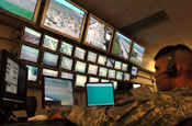  A National Guard Soldier watches a row of monitors in the communications department of the Yuma Sector Border Patrol Station in Arizona on July 27, 2006. The Soldier is assigned to the Wisconsin Army National Guard, which will be patrolling the Arizona-Mexico border with the Border Patrol in support of Operation Jump Start. DoD photo by Tech. Sgt. Brian E. Christiansen, U.S. Air Force.