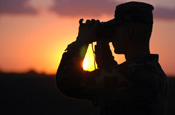 A National Guard member scans the horizon during sunset at San Luis, Ariz., on July 30. Soldiers and Airmen from the North Carolina National Guard are deployed in support of Operation Jump Start. Airmen are providing support for annual training by guardsmen who are working with U.S. Customs and Border Protection. (U.S. Air Force photo/Tech. Sgt. Brian E. Christiansen)