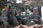 National Guard Soldiers take shelter from the bright New Mexico sun under the camouflage netting of their mountain top observation point. The Soldiers, members of the Arkansas National Guard's 39th Infantry Brigade Combat Team, are part of Task Force Arkansas participating in Operation Jump Start along the U.S. border with Mexico. (Photo by Maj. Keith Moore, Arkansas National Guard State Public Affairs Office.).