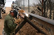 An Arizona Army National Guard Soldier, who is not being identified for security reasons, welds a railroad track to a support beam as part of an obstacle along the U.S. border with Mexico in the U.S. Border Patrol's Sonoita District in Arizona Thursday, Jan. 18, 2007. The obstacles are designed to discourage illegal aliens from coming into the United States. (U.S. Army photo by Sgt. 1st Class Gordon Hyde)