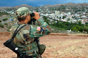An Arizona National Guard Soldier stands watch on the U.S. border with Mexico at Nogales, Ariz., in July, looking over the Mexican city also named Nogales. The Citizen-Soldier is a member of Alpha Company, 1st Battalion, 158th Infantry, 29th Infantry Brigade Combat Team participating in Operation Jump Start, the National Guard's assistance to the U.S. Border Patrol. Photo by Sgt. Jim Greenhill