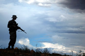 An Arizona National Guard Soldier stands watch on a ridge above Nogales, Ariz., at the U.S. border with Mexico in mid-July. Only those Guard troops whose mission may expose them to danger are armed for purposes for self-defense. The Citizen-Soldier is a member of Alpha Company, 1st Battalion, 158th Infantry, 29th Brigade Combat Team. (Photo by Sgt. Jim Greenhill, National Guard Bureau)