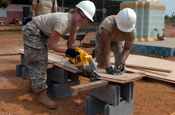 Pvt. 1st Class Michelle Almeida of Kihei, Hawaii and Sgt. 1st Class Brandon Cabanilla of Kahalui cut wood framing material for the windows in the new classroom facility the Hawaii National Guard, 230th Engineer Company, Vertical is building jointly with the Royal Thai Marine Engineer Battalion during the Cobra Gold joint engineering civil assistance mission hosted at the Ban Nong Buatong school in the Chanthaburi District of Thailand Jan. 24 to Feb. 11.