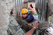 Tech. Sgt. Shawn Theberge, a medical technician with the 157th Medical Group, plays the role of a victim during a training exercise at the Santanita Fire Training Complex in San Salvador, El Salvador, as a member of the local fire department begins to extract him.Personnel from the New Hampshire Air National Guard traveled to San Salvador to participate in a Chemical Biological Radiological Nuclear High Yield Explosive Enhanced Response Force Package (CERFP) exchange with local search and rescue authorities. (U.S. Air Force photo by Tech. Sgt. Mark Wyatt) 
