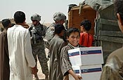 1st Lt. Robert Grutsch (left) and Maj. Martin Sayre of 1-34 Brigade Troops Battalion hand out boxes of school supplies to children of the new Coalition Forces built school in Um Eneej, Iraq. The supplies were donated by Community Connection of Sauk Center, Minn. Photo by Spc. Brian D. Jesness, 1/34 BCT Public Affairs.