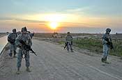 Sgt. Ed Raati of Chisholm, Minn., (left), Sgt. Danny Kraskey of Grand Rapids, Minn., Sgt. Brandon Combs of Horace, N.D., and Staff Sgt. Bradley Lahti of Robbinsdale, Minn., wait for cars to approach them to be searched Dec. 13 near Logistical Support Area Anaconda. All are Soldiers from Company C, 2nd Battalion, 136th Combined Arms Battalion, 1st Brigade Combat Team, 34th Infantry Division. Photo by Sgt. 1st Class Clinton Wood, 1/34 BCT PAO.