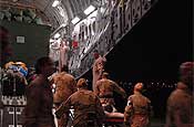 Air Force aeromedical evacuation team members load a patient onto a Mississippi Air National Guard C-17 Globemaster III at Balad Air Base, Iraq, on March 3 during a scheduled flight to Ramstein Air Base, Germany. (Photo by Tech. Sgt. Mike R. Smith, National Guard Bureau).