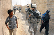 Spc. Adam Feldon, center, talks with an Iraqi boy, May 4, as a patrol of Pennsylvania Army National Guard Soldiers and Iraqi police officers moves through Taji market, north of Baghdad. The Keystone Guardsmen are from Company C, 1st Battalion, 112th Infantry Regiment, 56th Stryker Brigade Combat Team. (Photo by Sgt. Doug Roles, Pennsylvania National Guard)