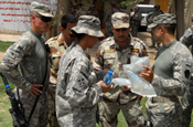  BAGHDAD - Medic Staff Sgt. Jose Martinez (at right), of Lebanon, Pa., hands bags of fluid to an Iraqi medic, May 17, after presenting a portion of the Army's Combat Lifesaver course to a class of Iraqi Soldiers. Martinez taught the class at Abu Ghraib where he and other Soldiers of the 2nd Battalion, 112th Infantry Regiment, 56th Stryker Brigade Combat Team.