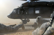  Staff Sgt. Craig Stevens (center) with Headquarters and Headquarters Company, 1st Battalion, 112th Infantry Regiment of the Pennsylvania Army National Guard, maneuvers through a cloud of dust to get into position between two other Soldiers, June 3, after dismounting the departing UH-60 Blackhawk helicopter. The 56th Stryker Brigade Combat Team Soldiers air assaulted into the desert near Nubai, northwest of Taji, along with Iraqi army soldiers to conduct searches for possible weapons caches. (Photo by Sgt. Doug Roles, Pennsylvania National Guard)