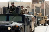 Aenior Airman Jonathon Ray sits atop the lead vehicle of a convoy of Humvees waiting to roll during a presidential security mission in Baghdad on Tuesday, June 13. Airman Ray is deployed from the Texas Air National Guard's 147th Fighter Wing at Ellington Field in Houston. (U.S. Air Force photo/Staff Sgt. Bryan Bouchard)