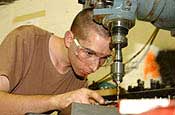 Senior Airman Daniel Lindsay uses a drill press at the metals technology shop in September at Balad Air Base, Iraq. Airman Lindsay is a Air National Guardsman deployed from Joe Foss Field, S.D., and assigned to the 332nd Expeditionary Maintenance Squadron. (U.S. Air Force photo/Senior Airman Kerry Solan-Johnson) 