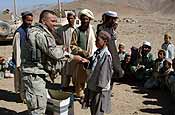 A U.S. Army Soldier with 102nd Infantry Regiment, Connecticut National Guard hands crayons to an Afghan boy during the humanitarian aid portion of a medical and veterinarian civic action program in Charkh, Afghanistan, Oct. 6, 2006. (U.S. Army photo by Sgt. Joey L. Suggs)