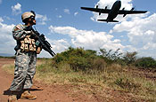Guam Army National Guardsman Specialist Vince Fejeran was part of a detail providing security on the ground as a C-130 Hercules flies a low altitude pass on it's way back to Camp Lemonier, Djibouti after delivering passengers and cargo to a 4,500-foot dirt strip runway in southern Ethiopia. The C-130 is deployed from Elmendorf Air Force Base, Alaska. Twice a week, C-130's fly cargo and passengers from the Combined Task Force - Horn of Africa headquarters in Djibouti to remote contingency operating locations throughout Ethiopia and Kenya. (U.S. Air Force photo/Master Sgt. Scott Wagers)