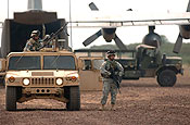 Guam Army National Guardsmen Specialists Albert Samana and Daniel Cruz move in to provide perimeter security for a C-130 Hercules delivering passengers and cargo to a U.S. contingency operating base in the remote village of Bilate, Ethiopia. The C-130 and crew are deployed to the Horn of Africa from Dyess Air Force Base, Texas. (U.S. Air Force photo/Master Sgt. Scott Wagers)