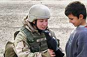Senior Airman Tara Cullen, a member of the 177th Security Forces Squadron, New Jersey Air National Guard, currently deployed to Kirkuk Regional Air Base, Iraq, gives a toy to a child during a recent patrol along the base perimeter. The items given out were donated by friends and family members from back home.