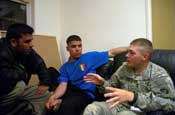 Spc Mark Belcourt of Hastings, Minn., Company B, 194th Combined Arms Battalion, interacts with Iraqi Policemen Feb. 15 at their headquarters in Anah, Iraq. Belcourt is a member of a Police Transition Team training the IPs here. Photo by Sgt. 1st Class Clinton Wood. 1/34 BCT PAO.