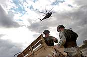 Exercise Granite Triangle - Spc. Adam Haggett, left, and Spc. Justin McNeff, both infantrymen with C Company, 3rd Battalion, 172nd Infantry Regiment (Mountain), prepare a humvee to be slingloaded under a U.S. Navy MH-53E Sea Dragon from Helicopter Mine Countermeasures Squadron 14 during Exercise Granite Triangle at Fort Pickett, Va.