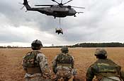 Exercise Granite Triangle - Soldiers from C Company, 3rd Battalion, 172nd Infantry Regiment (Mountain) watch as a U.S. Navy MH-53E Sea Dragon from Helicopter Mine Countermeasures Squadron 14 takes off with a slingloaded humvee during Exercise Granite Triangle at Fort Pickett, Va.