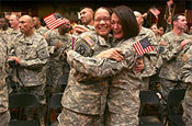 Spc. Kesha Stocks (center left) hugs Master Sgt. Cynthia Carlucci (center right), both of the 50th Personnel Services Battalion, New Jersey Army National Guard, during the singing of God Bless America at the Welcome Home Ceremony held at the National Guard Armory in Lawrenceville, New Jersey on March 9.