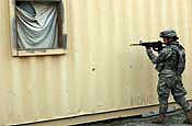Spc. Marta Koock, a healthcare specialist with Headquarters and Headquarters Company, 58th Infantry Brigade Combat Team, guards the window of a home of a suspected insurgent during training in Military Operations in Urban Terrain (MOUT) held at Fort Dix, N.J., Friday, May 10,2007. The 58th IBCT is at Fort Dix to train up for an upcoming deployment to Iraq. (U.S. Army Photo by Sgt. S. Patrick McCollum) (Released)