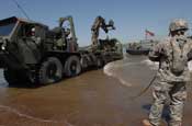 Soldiers from South Dakota Army National Guard's 200th Engineer Company loaded military vehicles and Soldiers from the 1133rd Transportation Battalion, Iowa Army National Guard, onto five float ribbon-bridge rafts and transported them across the water on Sunday, June 10, at the Missouri River in Chamberlain. The units being shuttled across the river will participate in the 2007 Joint Thunder Exercise. The exercise provides relevant training opportunities in support of the Global War on Terror and Homeland Defense, and is being held June 9–23 in the Northern Black Hills of South Dakota. More than 4,300 service members from 81 units representing 34 states are expected to participate in the 23rd annual Joint Thunder Exercise. Army National Guard photo by Sgt. 1st Class Donald Matthews.