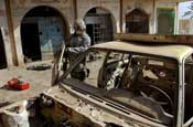  Sgt. Dustin Thompson, a team leader assigned to Company A, 1st Battalion, 149th Infantry Regiment, looks over an abandonned vehicle to check for explosives or weapons during a routine presence patrol through the Al Furat section of Baghdad, Thursday, Aug. 29, 2007. Soldiers from the unit have been working with local officials to assist with rebuilding schools and other facilities in the area. (U.S. Army photo by Staff Sgt. Jon Soucy) (Released)
