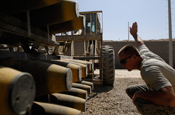 Staff Sgt. Todd Slate guides an all-terrain forklift driven by Airman 1st Class Jesse Carlin who is picking up several general purpose bombs July 24 at Joint Base Balad, Iraq. The bomb components are stored in different secure areas until they are needed for assembly. (U.S. Air Force photo/Airman 1st Class Jason Epley)