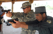 GHORWACH, Afghanistan - South Dakota National Guard Embedded Training Team member Staff Sgt. Adam Herrmann of Rapid City, S.D., describes proper pistol grip and firing techniques to an Afghan policeman in August near the village of Ghorwach in northwest Afghanistan. (Army National Guard photo by Sgt. 1st Class Darnell Hubbard)(RELEASED).